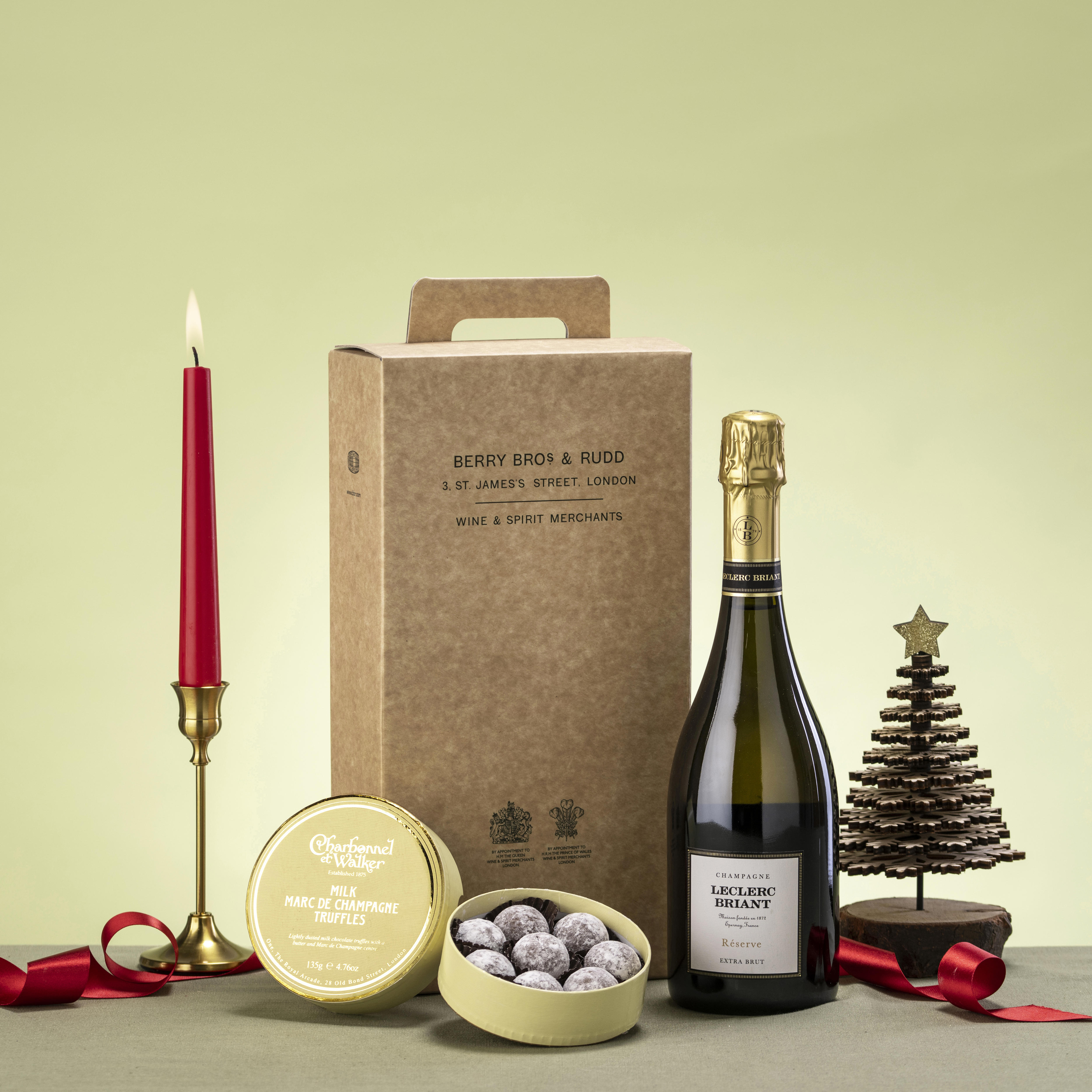 A festive giftbox with a bottle of sparkling wine and chocolate truffles. 